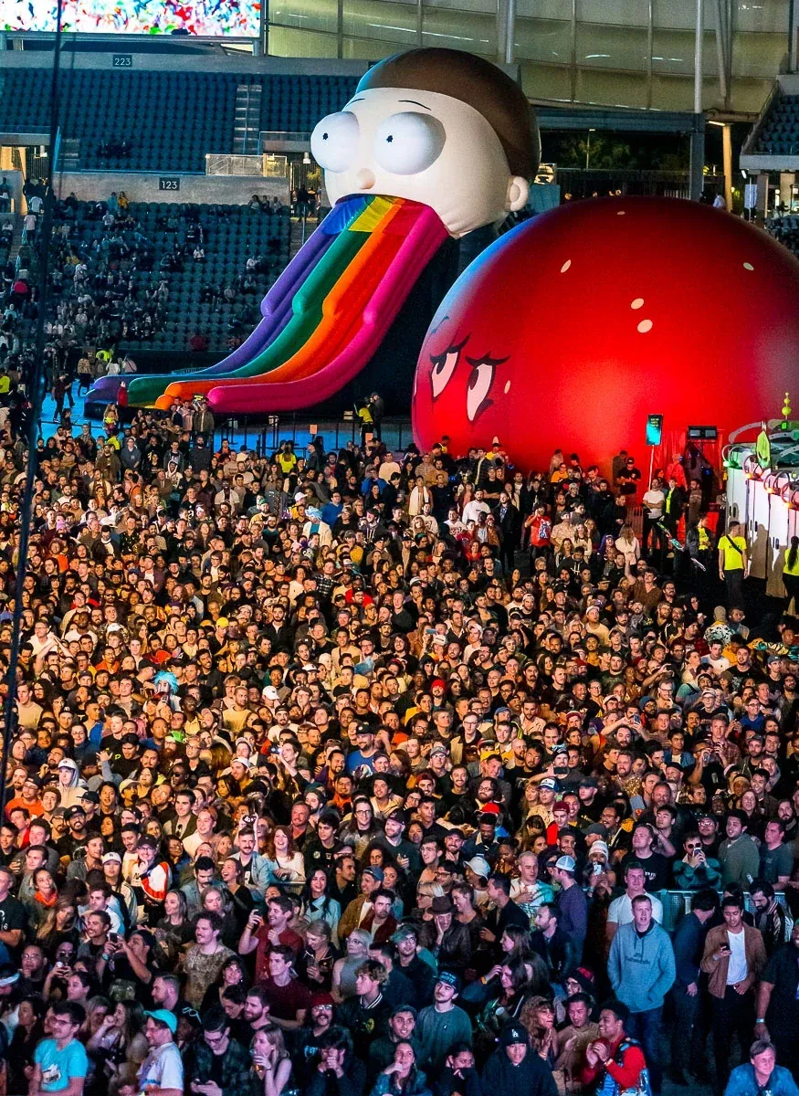 A packed crowd in front of giant Rick and Morty inflatables at Adult Swim Festival