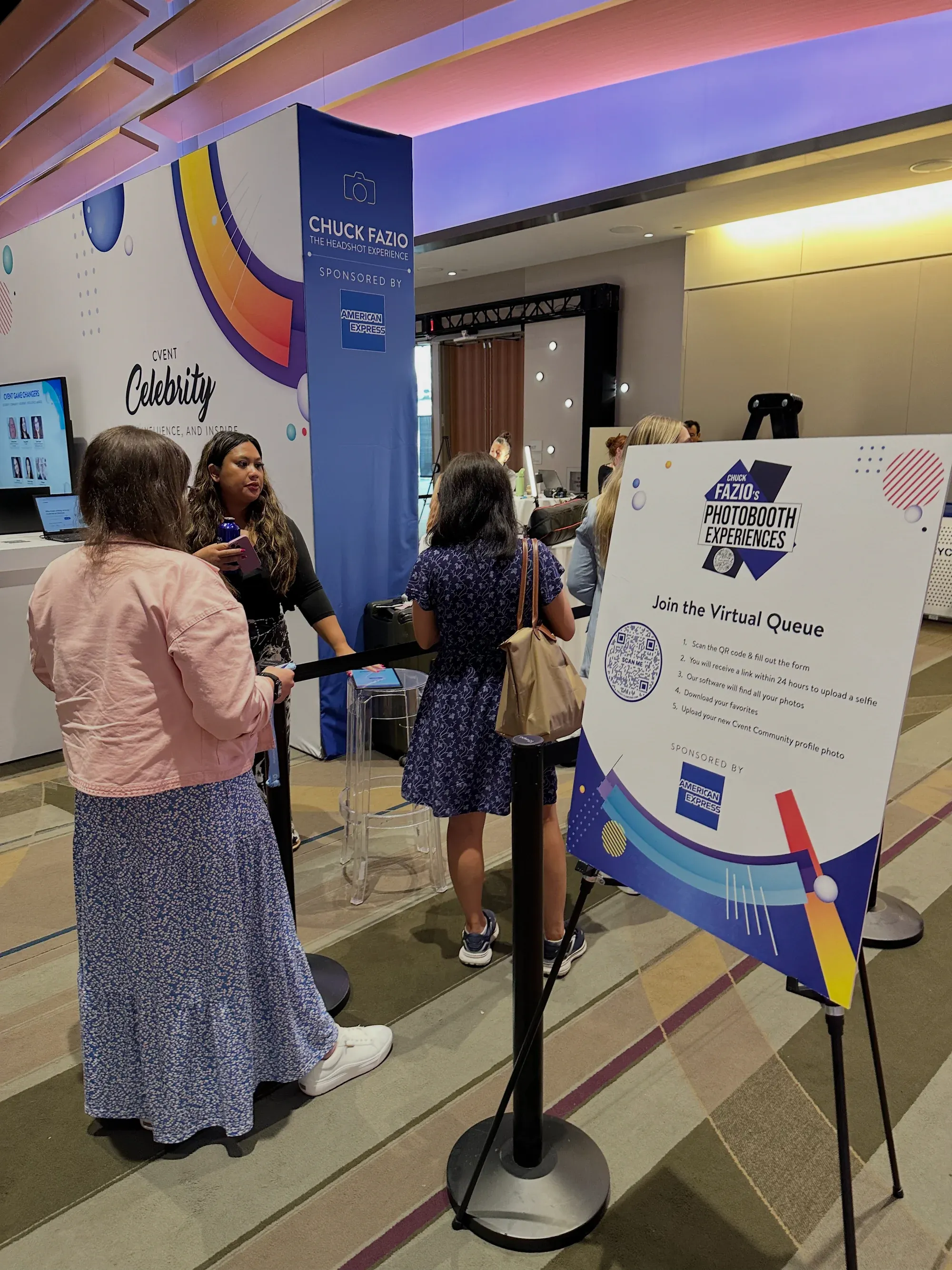 Attendees reading the Join the Virtual Queue sign at Chuck Fazio’s booth