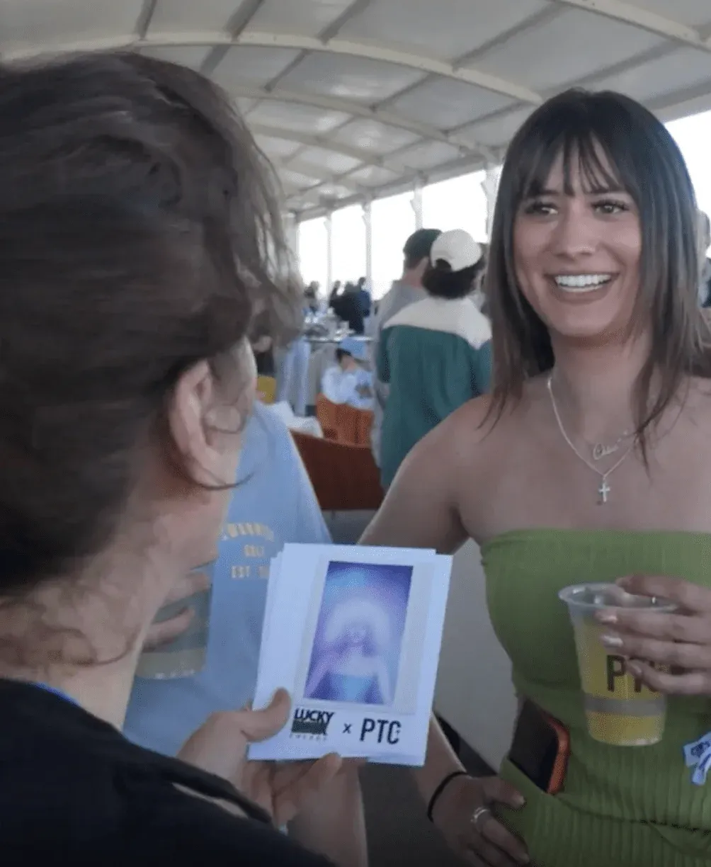 A guest smiling as she holds her aura reading print at the Lucky Energy activation