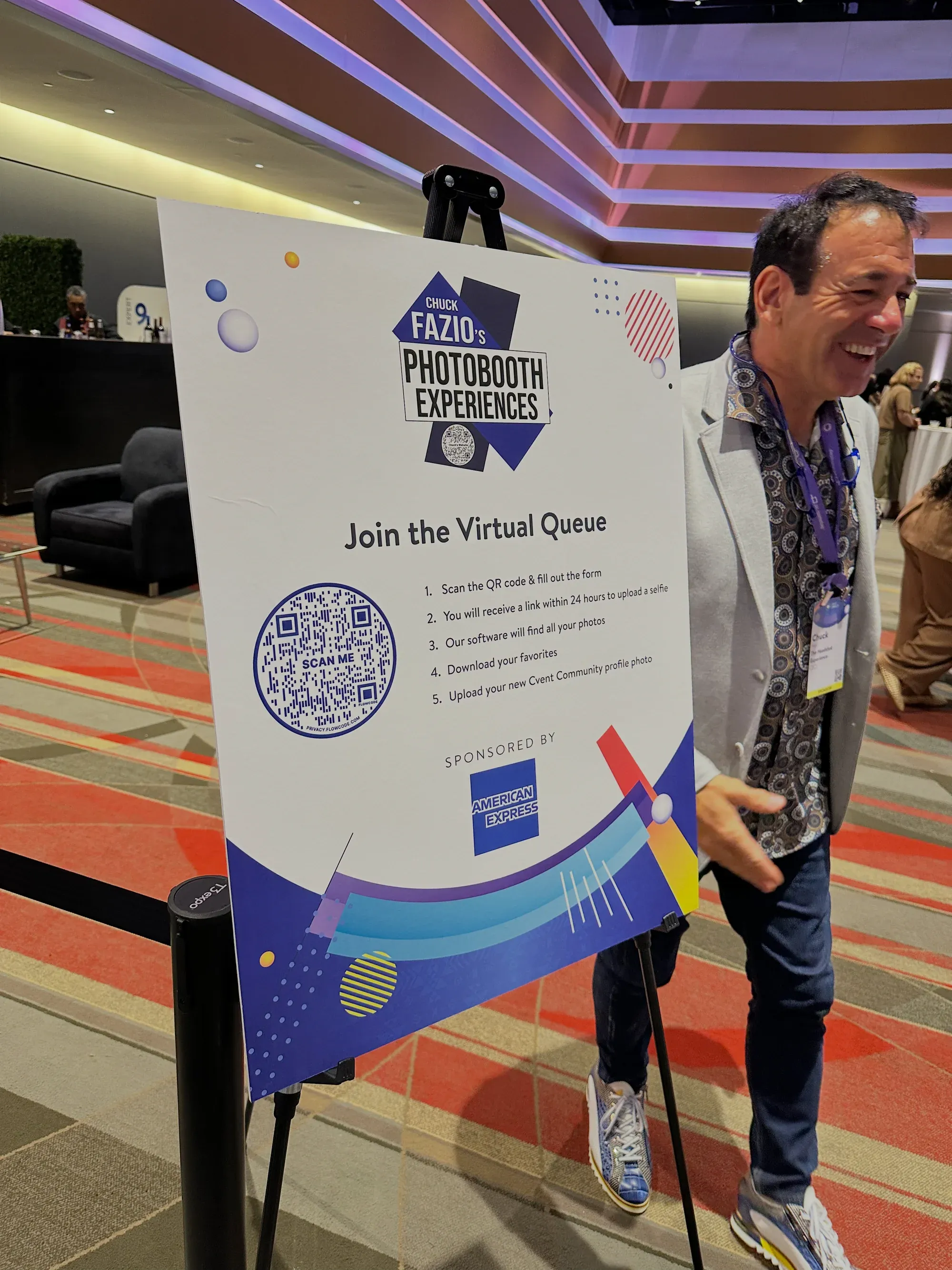 Chuck Fazio smiling next to a Join the Virtual Queue sign at his booth