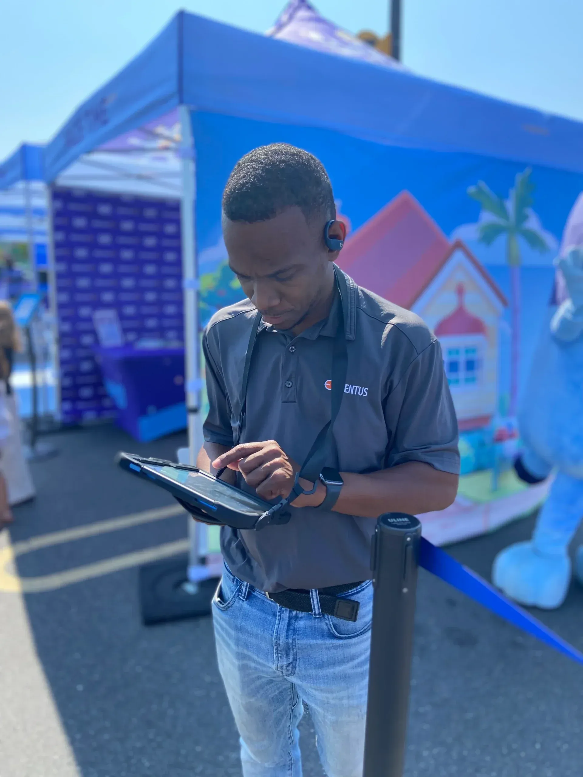 A field manager checking in guests on a tablet at the Bluey event