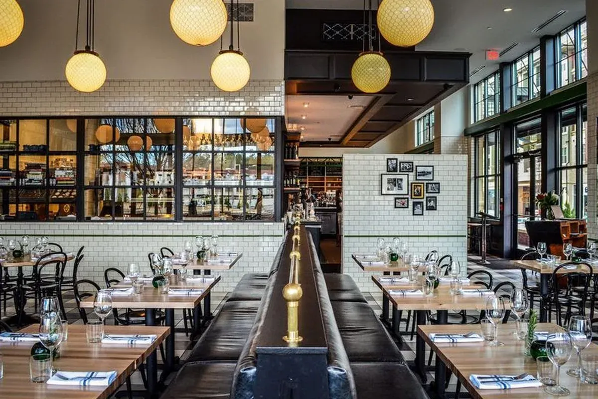 Dining room at The General Muir with subway-tile walls, globe pendant lights, and set wooden tables