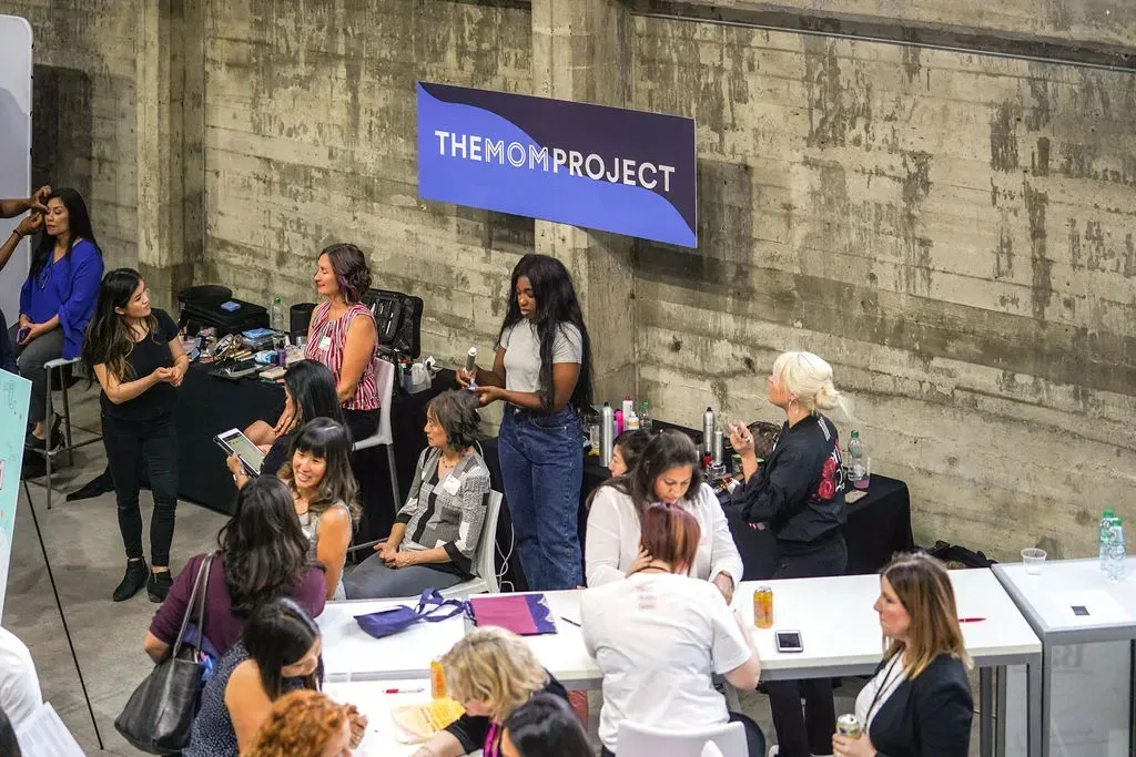 Stylists refreshing attendees’ hair and makeup at The Mom Project career fair
