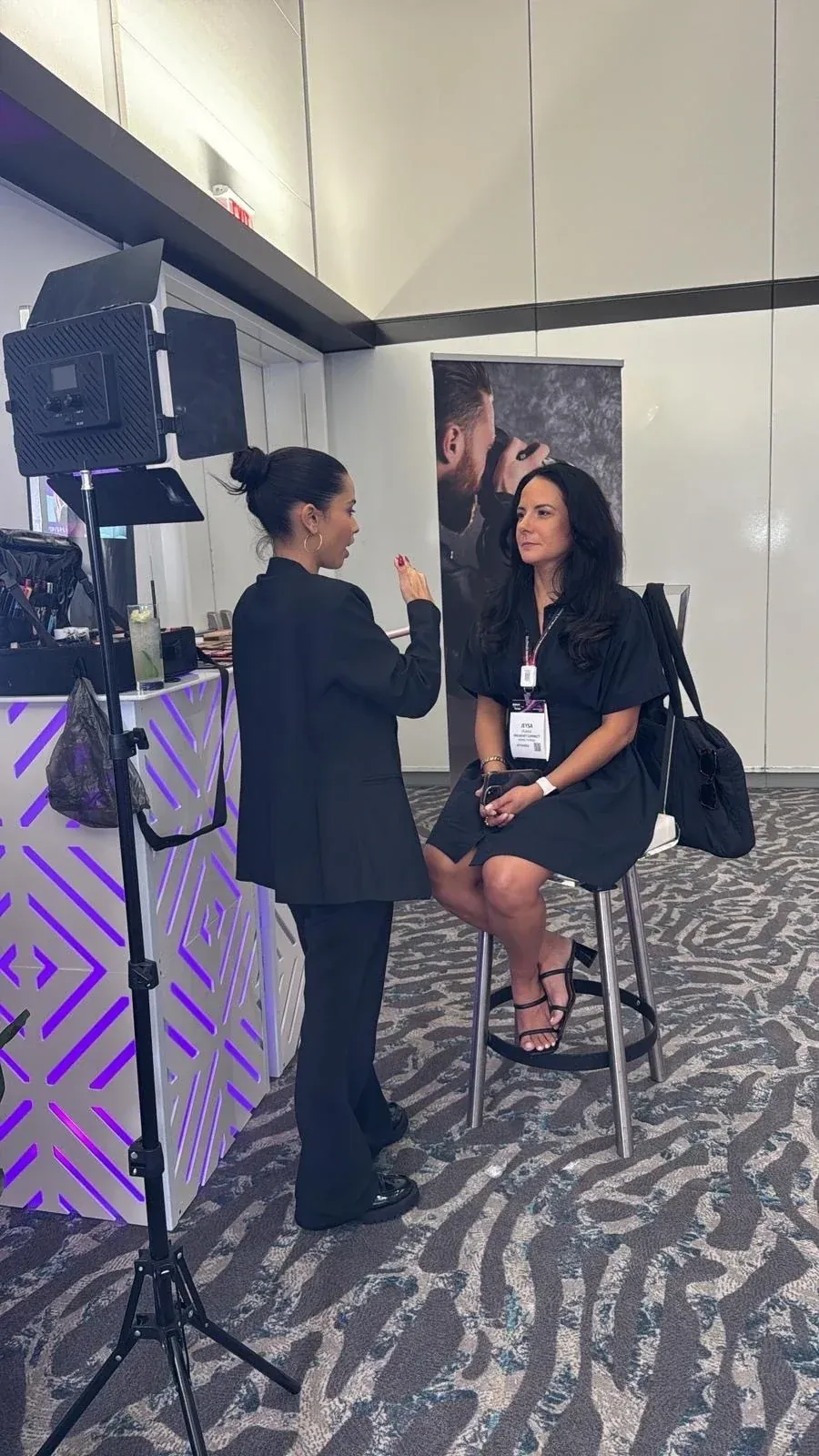 A goMLR makeup artist working with a summit attendee at the Glam Bar