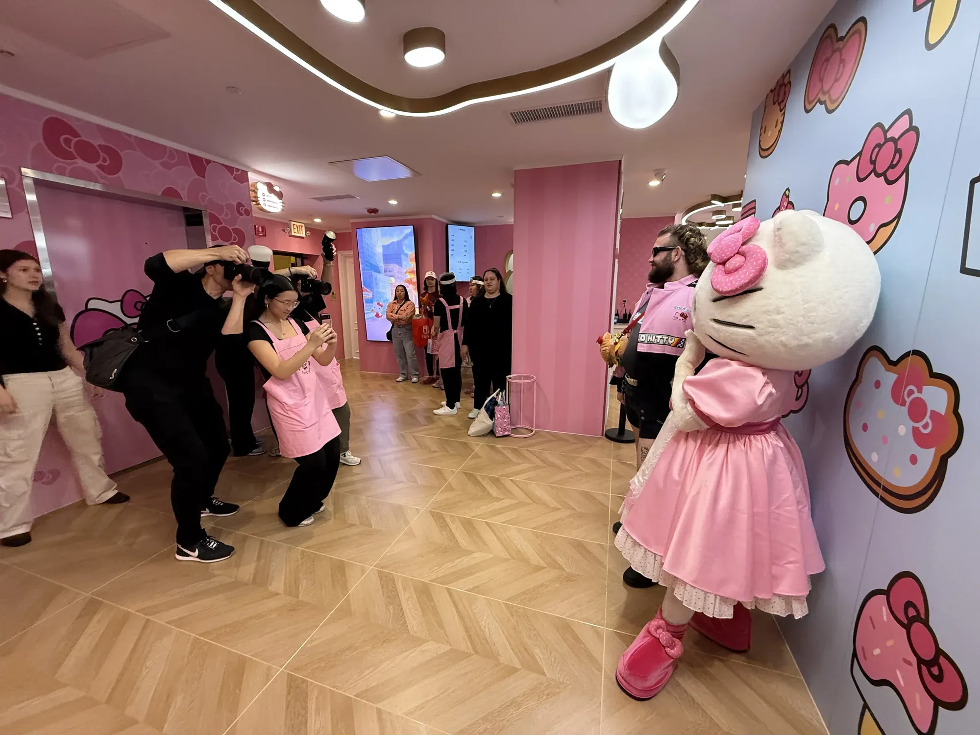 Guests taking photos with Hello Kitty inside the pink Hello Kitty Cafe Chicago