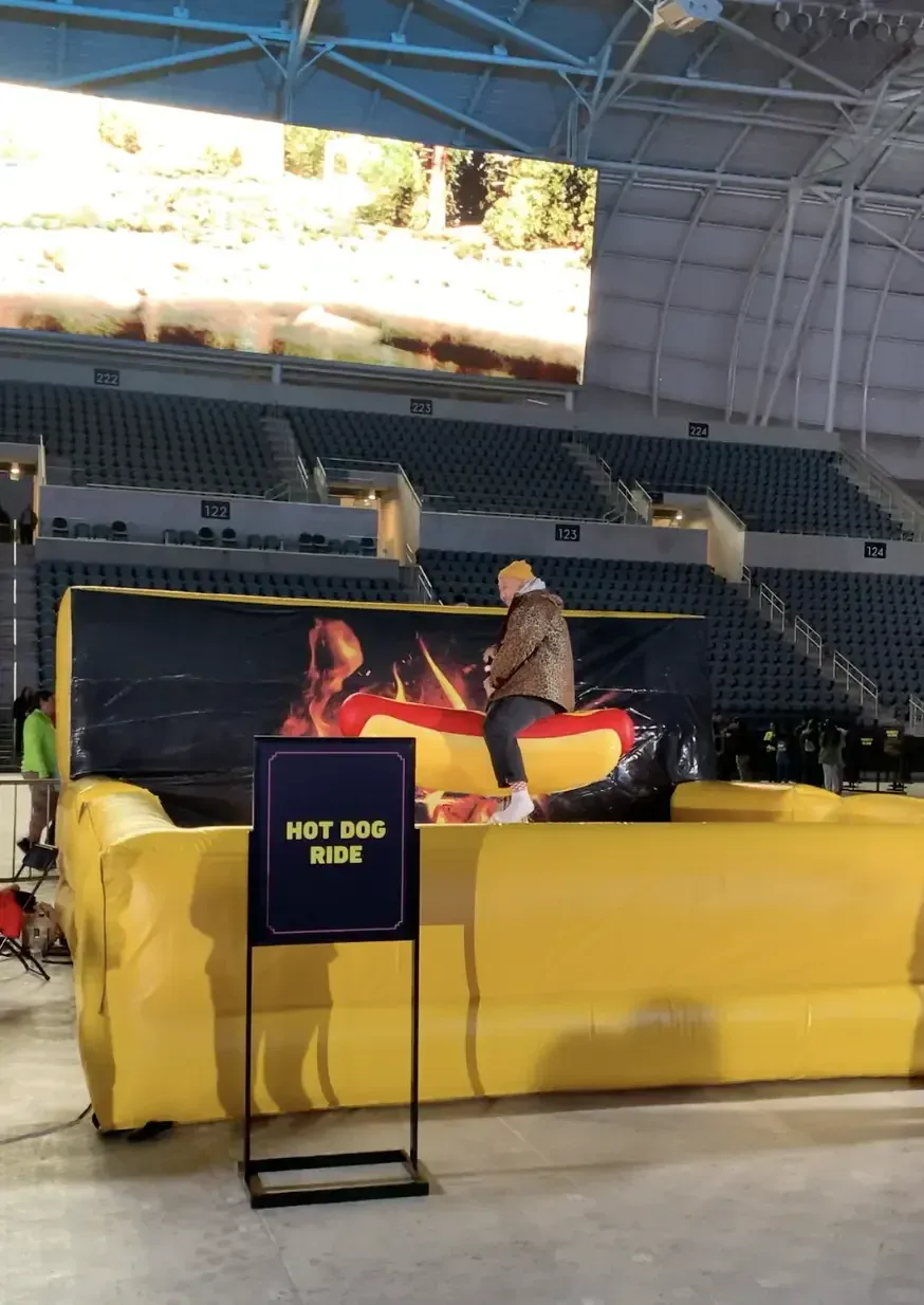 A guest riding the inflatable hot dog ride in the stadium