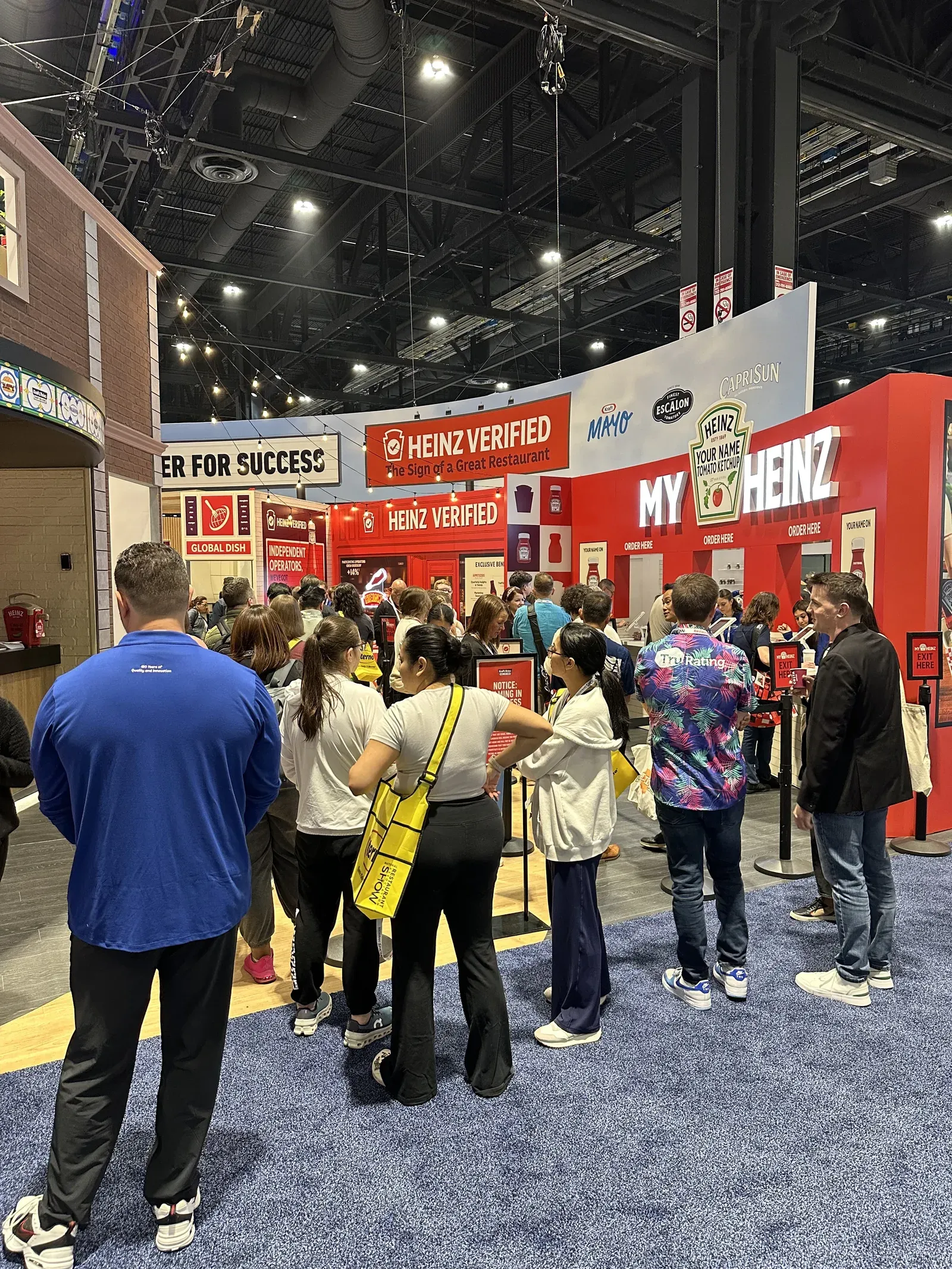 Crowd of trade show attendees bunched up waiting at the red My Heinz booth at the National Restaurant Association Show