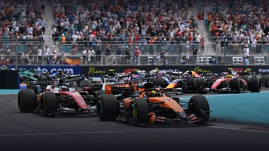 Formula 1 cars racing past a packed grandstand at the Miami Grand Prix