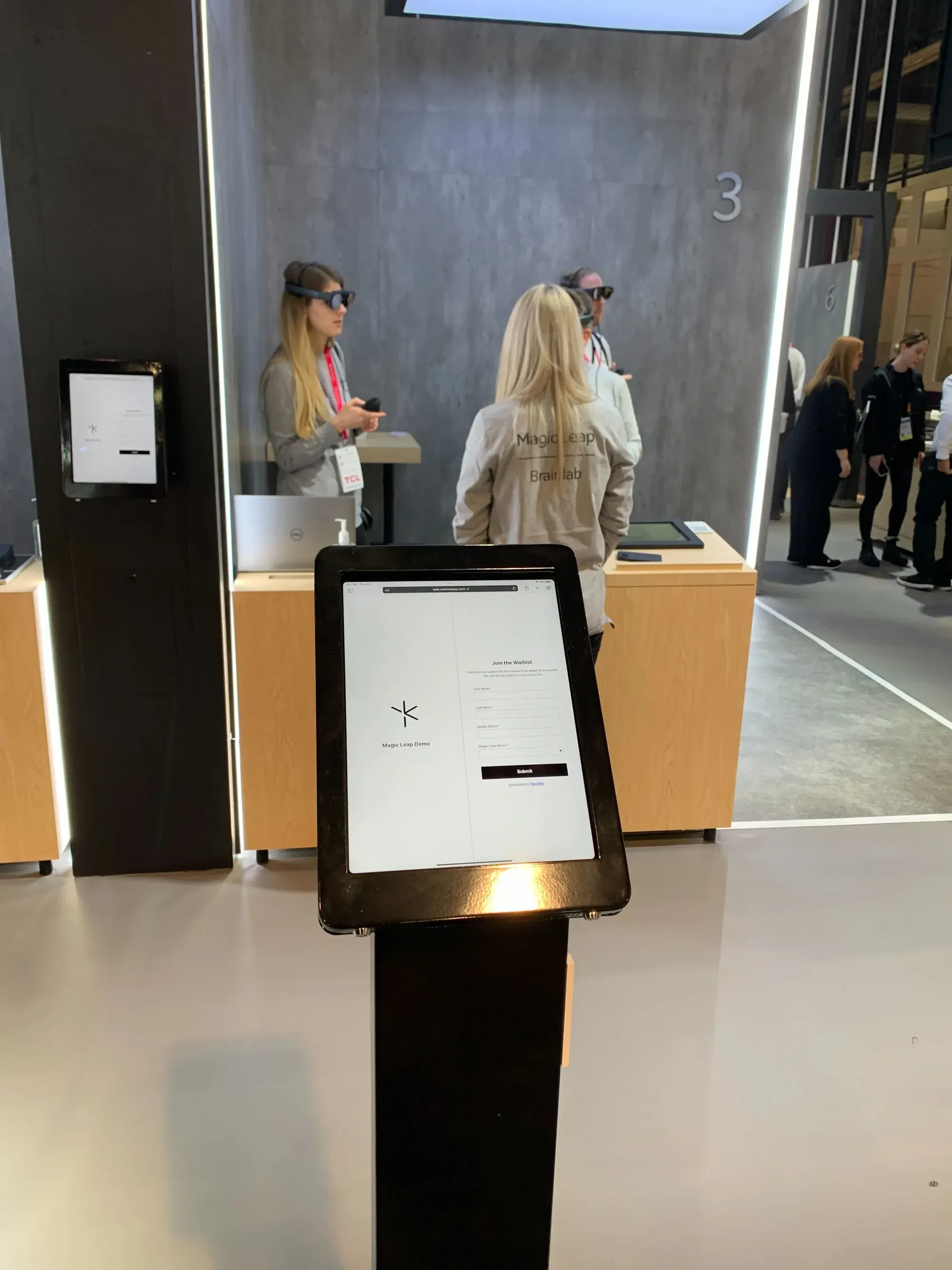 A self check-in kiosk at the Magic Leap booth, with attendees in the background