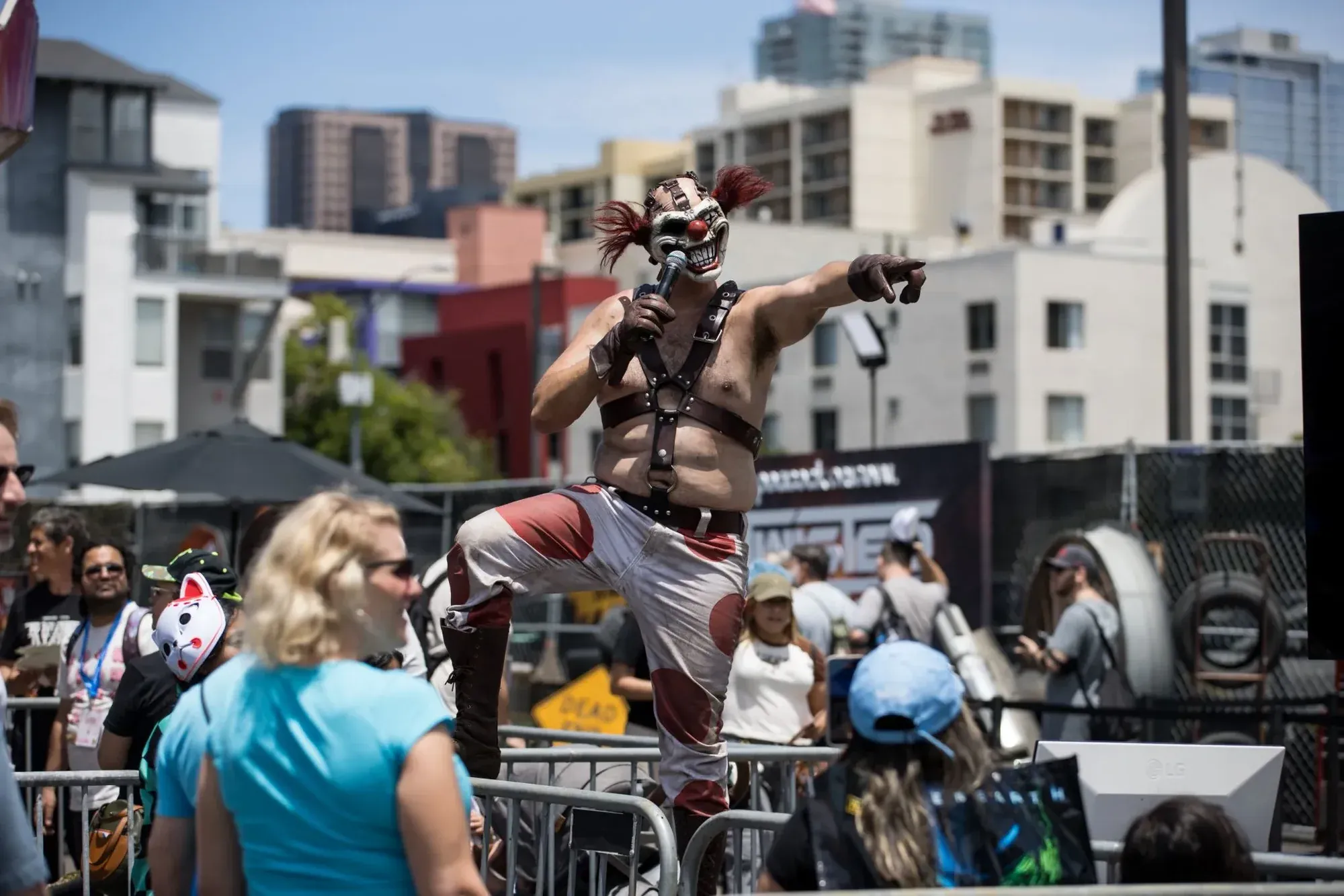 A masked Twisted Metal performer posing above the crowd at the activation