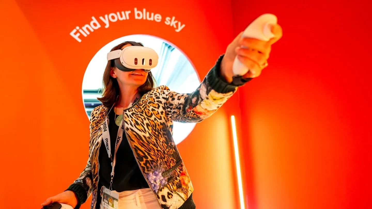 An attendee wearing a VR headset reaches out inside an exhibit at the SXSW XR Experience
