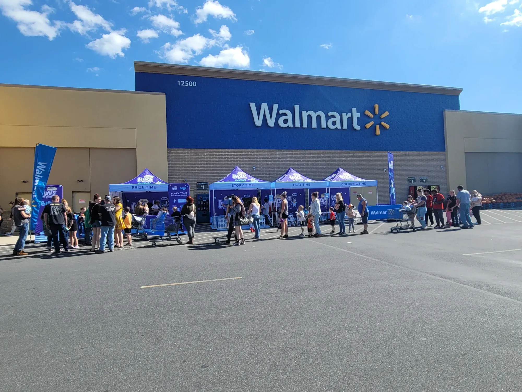 Families lined up at the Bluey Meet & Greet tents outside a Walmart store