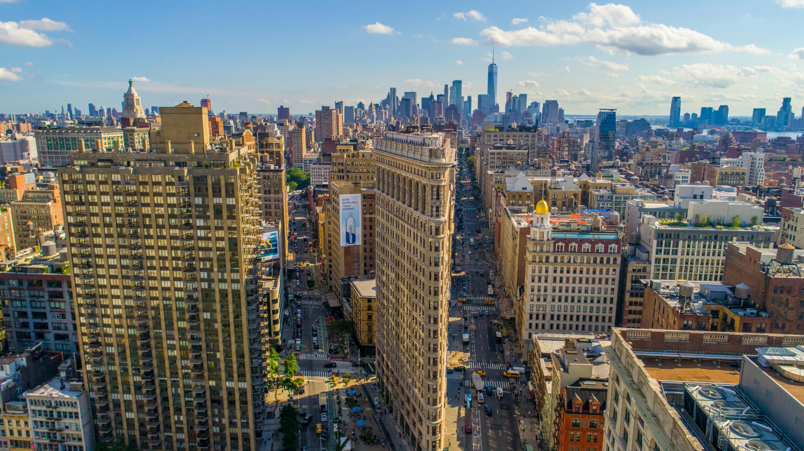 Stunning aerial view of New York City's skyline featuring the iconic Flatiron Building on a sunny day.